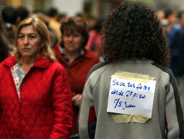Una joven lleva a la espalda un cartel en el que ofrece su piso de calle San Juan para tomar las mejores fotograf&iacute;as. 

Foto: Sergio Camacho