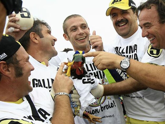 Valentino Rossi (Yamaha) celebra el t&iacute;tulo con sus seguidores, que llevaban tambi&eacute;n camisetas con la leyenda "Gallina vieja hace buen caldo" y una gallina viva.

Foto: Afp Photo / Efe / Reuters