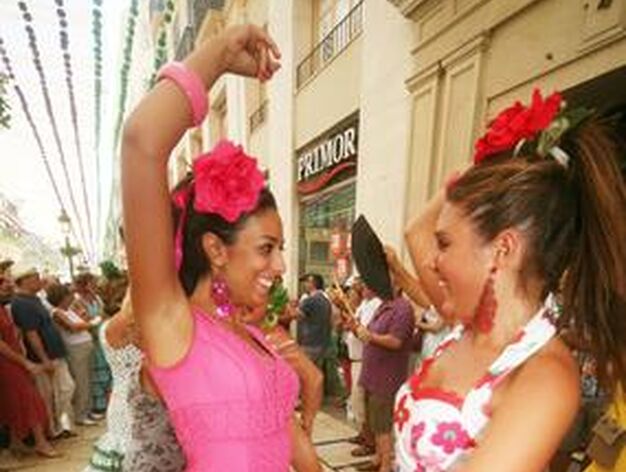 Dos j&oacute;venes bailando sevillanas en la Calle Larios.

Foto: PUNTO PRESS