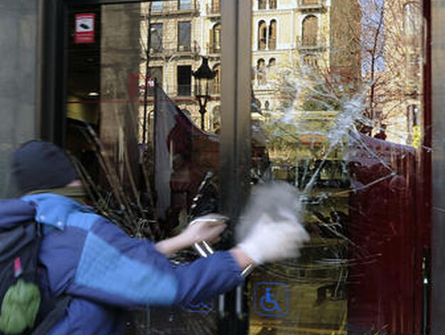 Un joven lanza piedras y bolas de pintura contra un banco.

Foto: AFP Photo