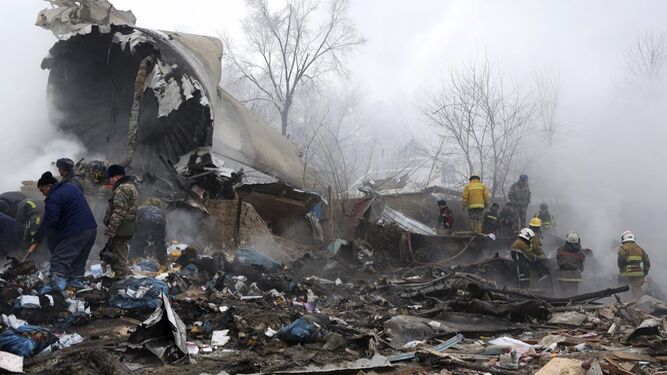 Los servicios de emergencias entre los restos del avión siniestrado.