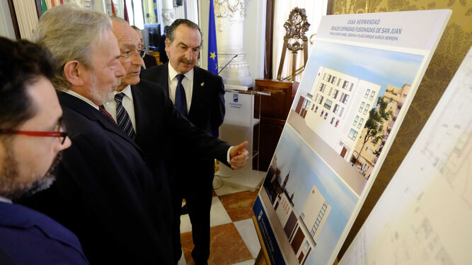 Pomares, De la Torre y Rosell, ayer, observan uno de los paneles con las imágenes de la futura casa hermandad.