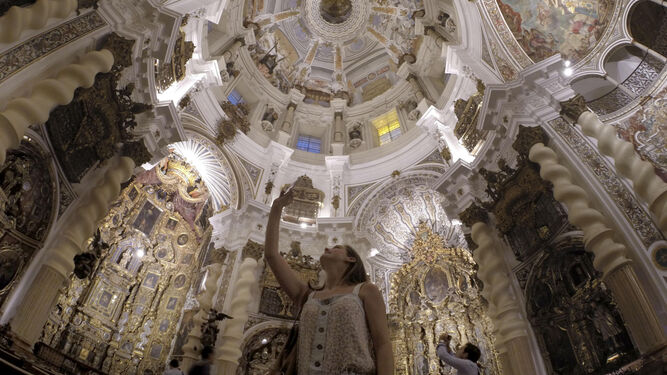 Una joven contempla la cúpula de la iglesia, joya del barroco promovida por los jesuitas en el siglo XVII.