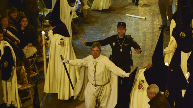 Un diputado de tramo y un Policía Local intentan calmar a los nazarenos de la Macarena en Sierpes.