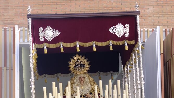 El Cristo Yacente se refleja en un escaparate de calle Álamos.