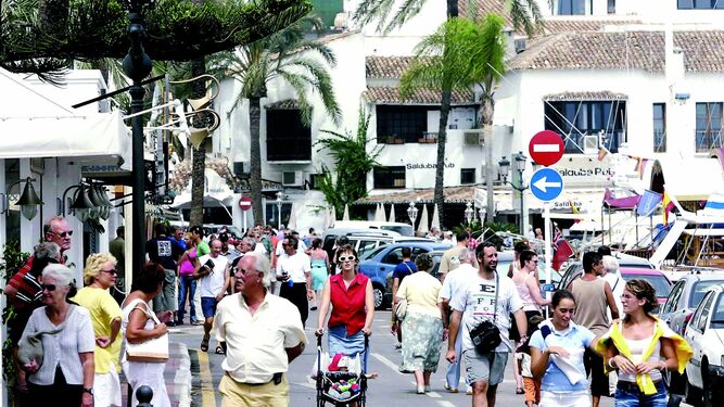Centenares de personas pasean por Puerto Banús en Marbella.