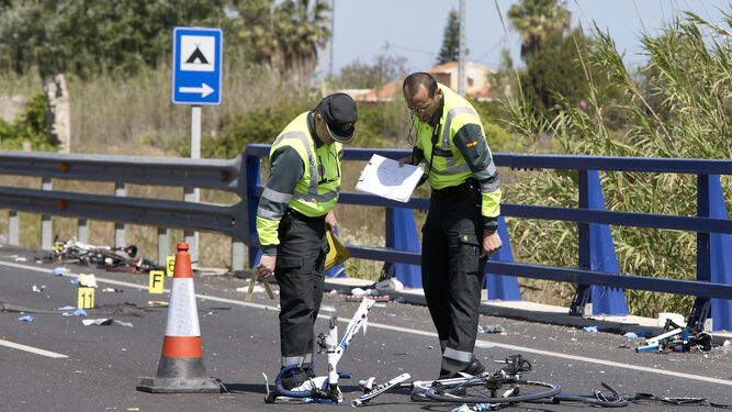 Agentes de la Guardia Civil y miembros de Emergencias en el punto donde la conductora de un turismo arrolló a un grupo de seis ciclistas.