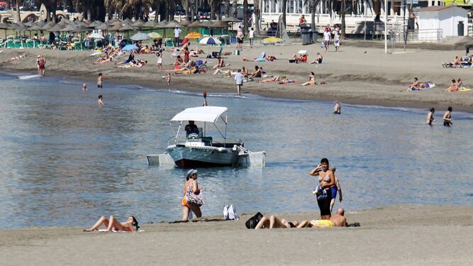Un barco quitanatas en una playa de Málaga.