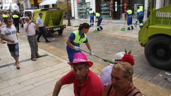 Operarios de Limasa limpian la calle Larios tras una jornada de Feria.