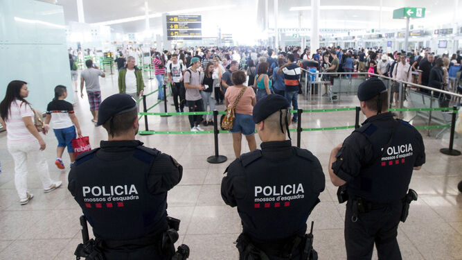Agentes de los Mossos d'Esquadra controlan los accesos a las puertas de embarque en el Aeropuerto de El Prat.