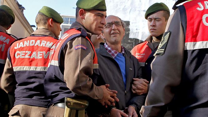 El escritor Dogan Akhanli rodeado de agentes de la policiía turca en Estambul en 2010.