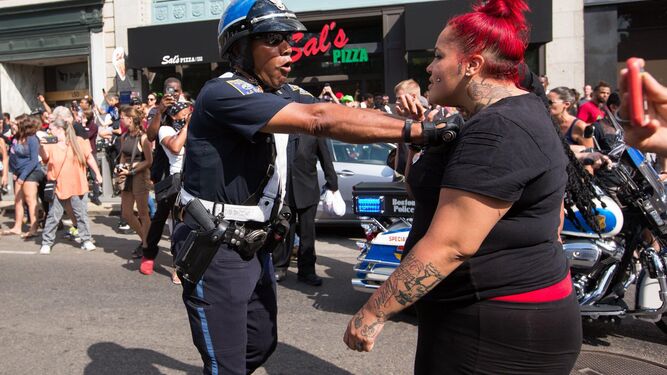 Un agente de la Policía empuja a una manifestante contra la marcha pronazi celebrada en Boston.