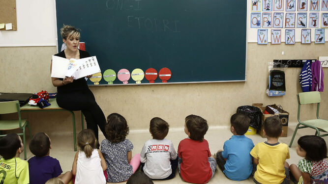 Alumnos de Infantil atienden las explicaciones de una maestra durante el desarrollo de una clase.