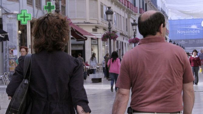 Una pareja pasea por la calle Larios en Málaga.