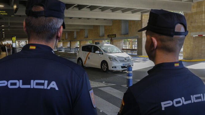 Dos agentes de Policía en el aeropuerto de Sevilla junto a la parada de taxis.