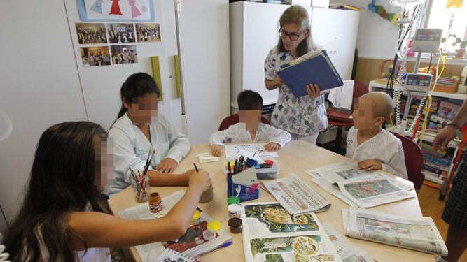 Los menores ingresados realizan actividades en una de las aulas hospitalarias con la profesora Elisa Bernárdez, con más de treinta años de trayectoria en el centro.