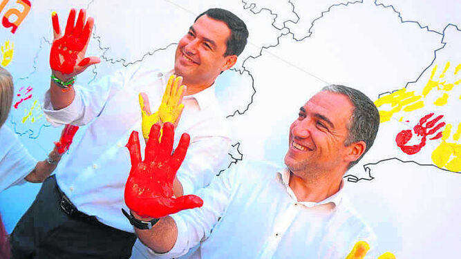 Moreno y Bendodo, ayer, con las manos con pintura de los colores de la bandera.