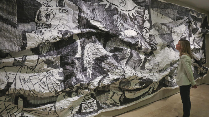 Una mujer contempla la obra 'Guernica XL, serie extrujados' del cántabro Javier Arce.