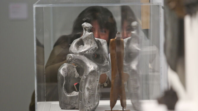 Una visitante observa un par de esculturas de Jorge Oteiza.
