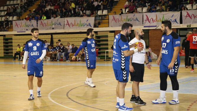 Los jugadores del GAES Málaga hablan con el cuerpo técnico con el tiempo parado.