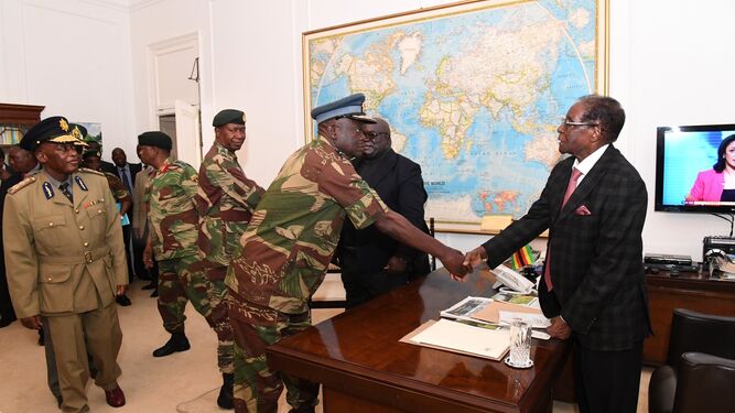 El presidente de Zimbabue, Robert Mugabe, saluda al comandante de las Fuerzas Aéreas del país tras una reunión con jefes militares, el domingo en Harare.