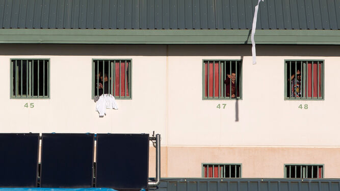 Un grupo de inmigrantes se asoma por la ventana en la cárcel de Archidona.