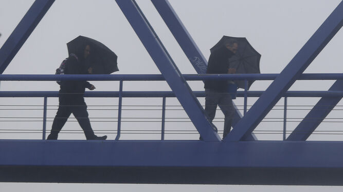 Dos hombres se protegen de la lluvia el pasado lunes.