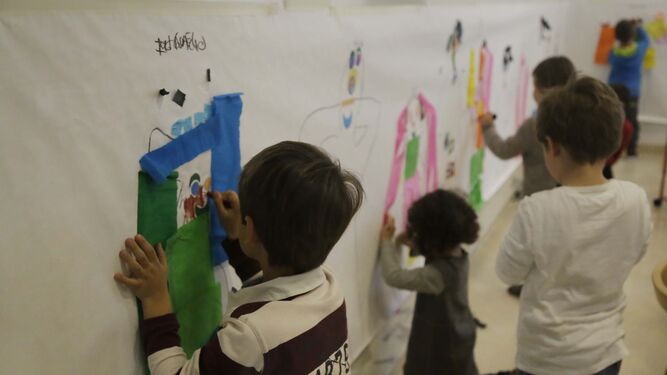 Niños pintan un mural en una actividad organizada en semana blanca.