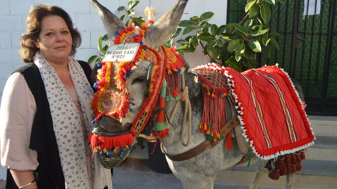 Lourdes Díaz, artesana talabartera, junto a uno de sus burros.