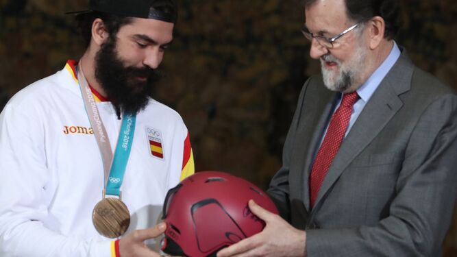 Rajoy le entrega al medallista Regino Hernández un casco firmado.