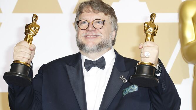 Guillermo del Toro posa con dos estatuillas.