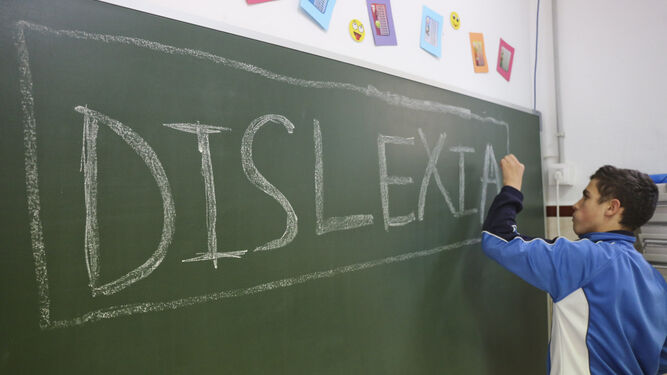 Antonio, alumno del colegio La Goleta con dislexia, escribe en la pizarra de un aula.