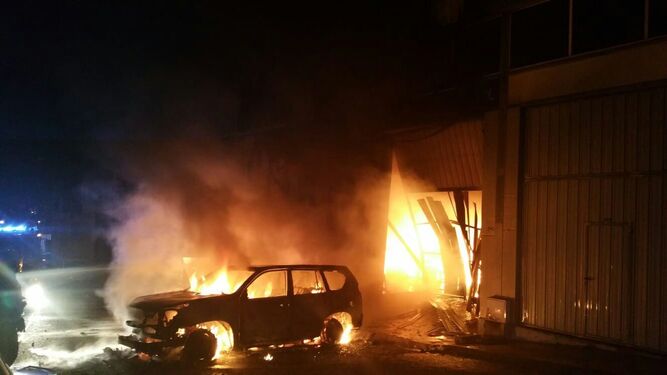 El vehículo y el local afectados, en llamas.