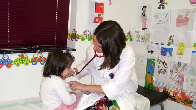 Una pediatra atiende a una niña en su consulta.