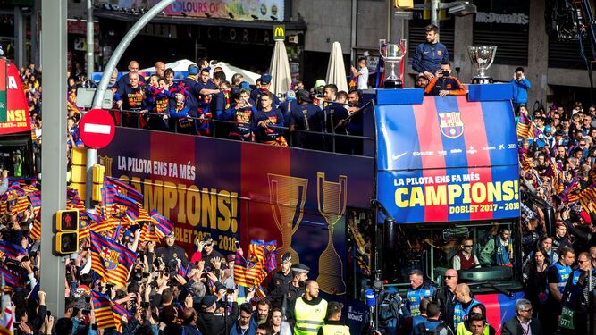 Los jugadores del Barcelona, en el autobús con los trofeos de Liga y Copa.