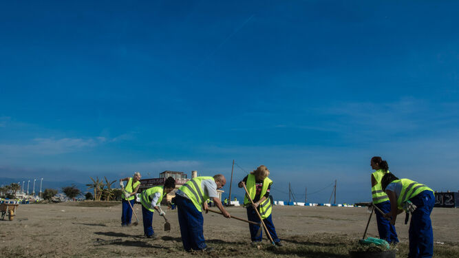 Trabajadores limpian la playa de la Misericordia.