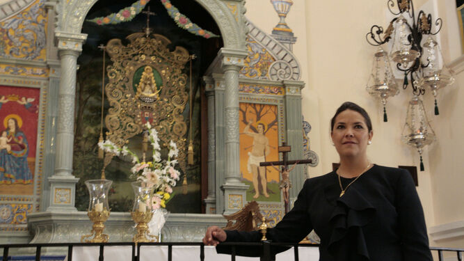 La hermana mayor del Rocío de Huelva, Cinta Burguillos, posa ante el Simpecado de la filial onubense.