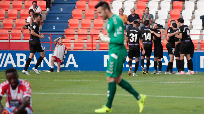 Los jugadores del Málaga, al fondo, celebran el resultado.
