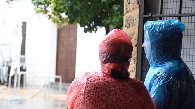 Dos personas se refugian de la lluvia en Córdoba.
