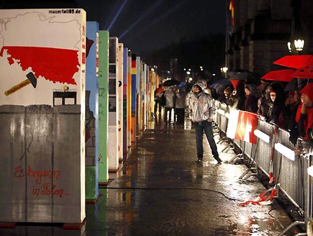Los ciudadanos pasean junto al domin&oacute; gigante que recorre el trazado original del Muro.

Foto: Agencias