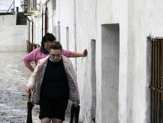 Dos mujeres andan sobre el agua en una calle de Lora del R&iacute;o.

Foto: Juan Carlos V&aacute;zquez