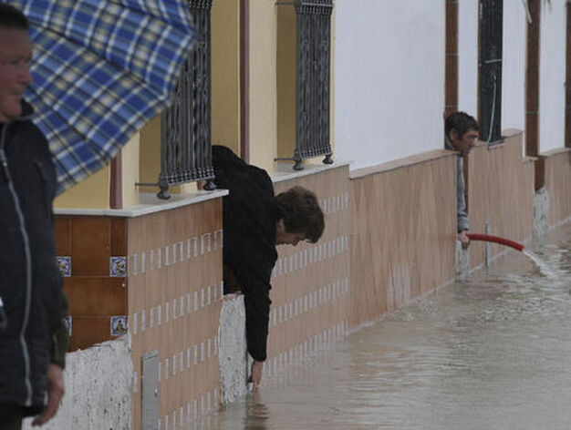 Vecinos de Tocina achican el agua de sus casas.

Foto: Juan Carlos V&aacute;zquez