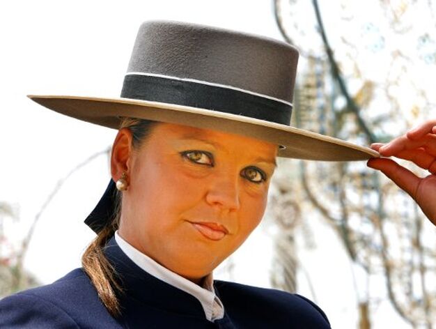 Una guapa joven posa en el recinto feria sosteniendo su sombrero de ala ancha

Foto: pascual
