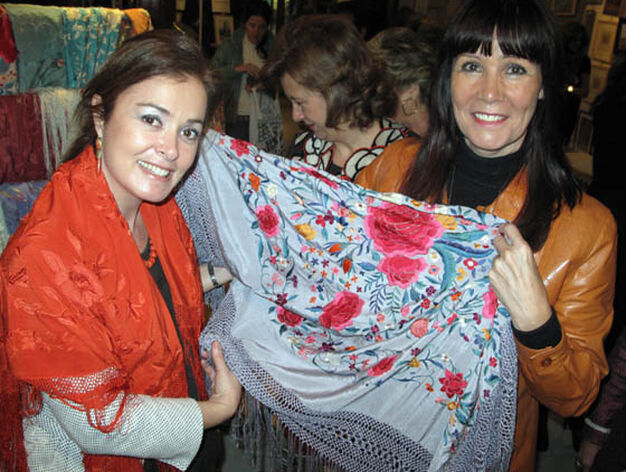 La consejera de Igualdad, Micaela Navarro (a la derecha de la imagen), aprecia la calidad de uno de los mantones que se venden en el Rastrillo.

Foto: Victoria Ram&iacute;rez