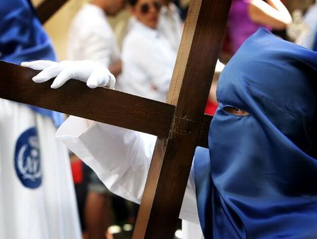 Un penitente de la hermandad de la Borriquita porta una cruz tras el paso de misterio.

Foto: Pascual