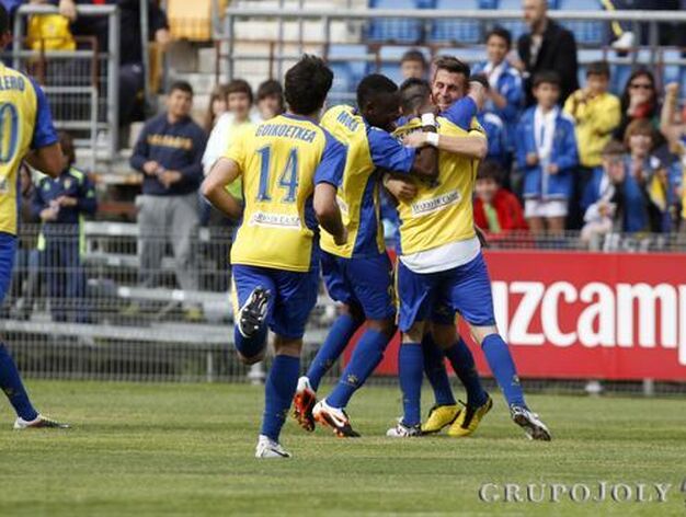 Los futbolistas amarillos abrazan al sevillano tras su gol. 

Foto: Lourdes de Vicente