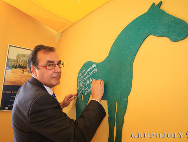 El director gerente de la Escuela, Juan Carlos Rom&aacute;n, escribiendo su dedicatoria en otro de los caballos que decoran la caseta de Diario de Jerez.

Foto: Vanesa Lobo