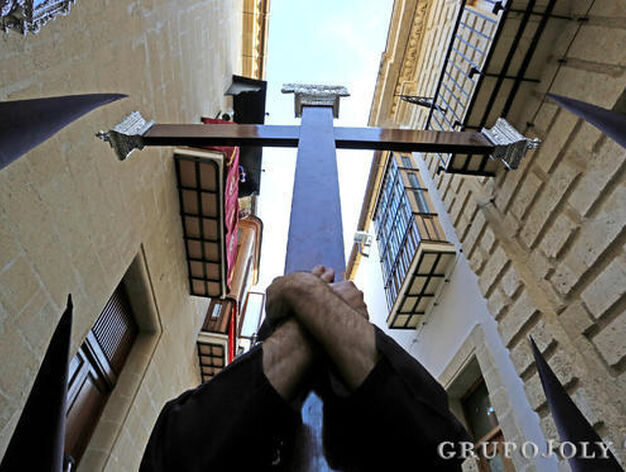 Un nazareno de la hermandad carmelita utiliza los dos brazos para llevar la cruz de gu&iacute;a por la ciudad.

Foto: Pascual