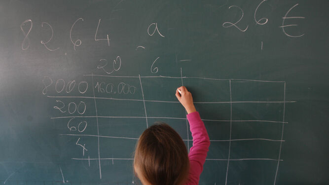 Una niña escribe en la pizarra durante la clase de Matemáticas.