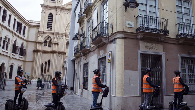 Un grupo de visitantes se desplaza en unos 'segways' por el centro histórico de Málaga.